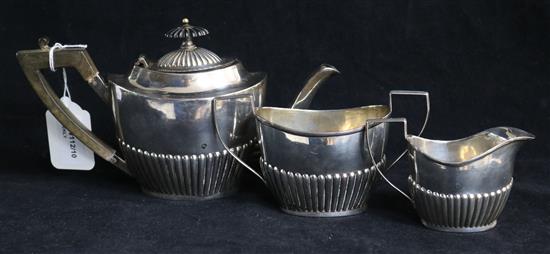 A three-piece silver bachelor tea service, of oval half-fluted form, Birmingham 1893, Hilliard & Thomason, 14oz approx